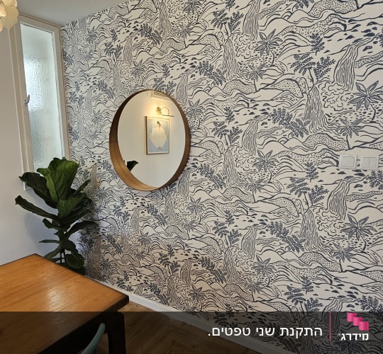 קיר עם טפט מעוצב, מראה עגולה וצמח ירוק